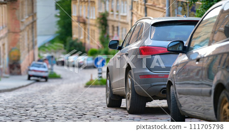 City traffic with cars parked in line on street side. 111705798
