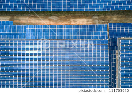 Aerial view of solar power plant with blue photovoltaic panels mounted on industrial building roof for producing green ecological electricity. Production of sustainable energy concept. 111705920