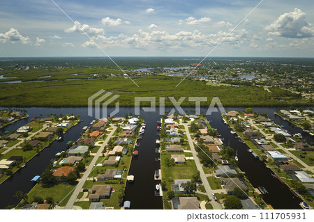 Aerial view of rural private houses in remote suburbs located near Florida wildlife wetlands with green vegetation on sea bay shore. Living close to nature concept 111705931