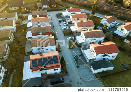 Aerial view of residential houses with red roofs and streets with parked cars in rural town area. Quiet suburbs of a modern european city. Aerial view of residential houses with red roofs and streets with parked cars in rural town area. Quiet suburbs of a modern european city. 111705936