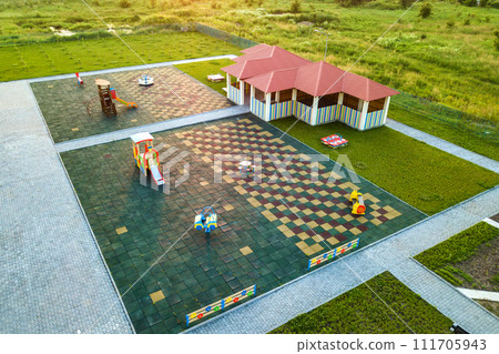 Aerial view of new alcove in kindergarten play yard with red tiled roof for outdoor children activities. 111705943