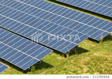 Aerial view of large sustainable electrical power plant with rows of solar photovoltaic panels for producing clean electric energy. Concept of renewable electricity with zero emission Aerial view of large sustainable electrical power plant with rows of solar photovoltaic panels for producing clean electric energy. Concept of renewable electricity with zero emission 111705958