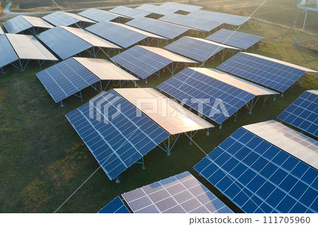 Aerial view of large sustainable electrical power plant with rows of solar photovoltaic panels for producing clean ecological electric energy. Renewable electricity with zero emission concept. Aerial view of large sustainable electrical power plant with rows of solar photovoltaic panels for producing clean ecological electric energy. Renewable electricity with zero emission concept. 111705960