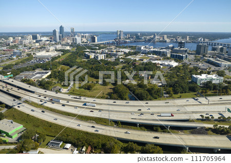Aerial view of Jacksonville city with high office buildings and american freeway intersection with fast driving cars and trucks. View from above of USA transportation infrastructure Aerial view of Jacksonville city with high office buildings and american freeway intersection with fast driving cars and trucks. View from above of USA transportation infrastructure 111705964