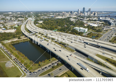 Aerial view of Jacksonville city with high office buildings and american freeway intersection with fast driving cars and trucks. View from above of USA transportation infrastructure Aerial view of Jacksonville city with high office buildings and american freeway intersection with fast driving cars and trucks. View from above of USA transportation infrastructure 111705965