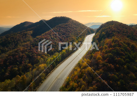 Aerial view of empty I-40 freeway in North Carolina leading to Asheville through Appalachian mountains in golden fall season. Energy crisis and high gas prices concept Aerial view of empty I-40 freeway in North Carolina leading to Asheville through Appalachian mountains in golden fall season. Energy crisis and high gas prices concept 111705987