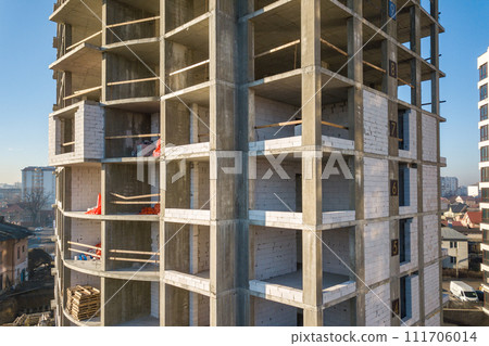 Aerial view of concrete frame of tall apartment building under construction in a city. Aerial view of concrete frame of tall apartment building under construction in a city. 111706014
