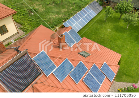 Aerial view of a new autonomous house with solar panels and water heating radiators on the roof. 111706050