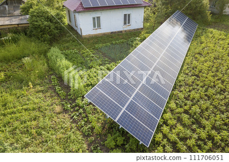 Aerial view of a house with blue solar panels for clean energy. Aerial view of a house with blue solar panels for clean energy. 111706051