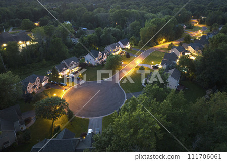 Aerial night view cul-de-sac road and spacious illuminated family houses in upstate New York suburban area. Real estate development in american suburbs Aerial night view cul-de-sac road and spacious illuminated family houses in upstate New York suburban area. Real estate development in american suburbs 111706061