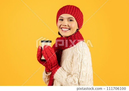 Happy lady holds cup of hot coffee on yellow background 111706100