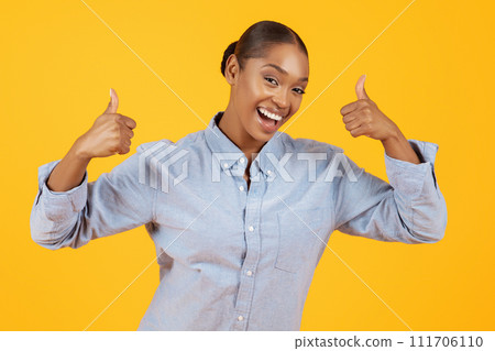 Excited African American Lady Showing Like Gesture Over Yellow Background 111706110