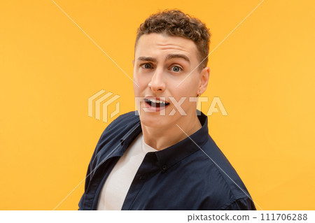 Closeup of young guy looking at camera, raising brow 111706288