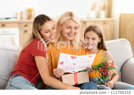Adoring adult daughter and her young granddaughter embrace their grandmother Adoring adult daughter and her young granddaughter embrace their grandmother 111706310