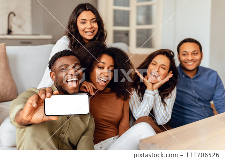 multiethnic friends making selfie using phone with empty screen indoors 111706526