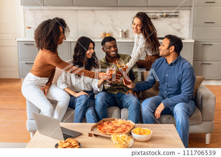 Joyful diverse students gather for party indoors clinking beer glasses 111706539