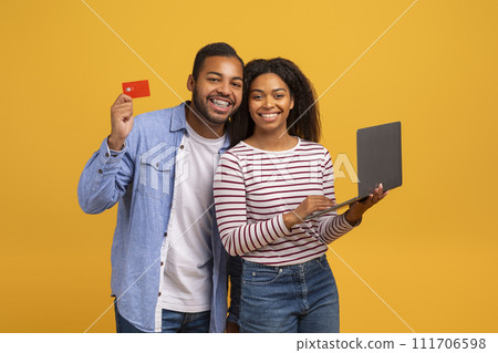 Online Shopping Concept. Happy Black Couple Using Credit Card And Laptop Together Online Shopping Concept. Happy Black Couple Using Credit Card And Laptop Together 111706598