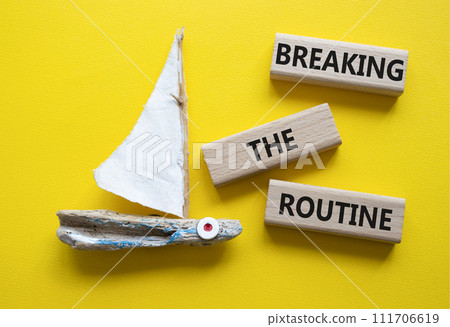 Breaking the Routine week symbol. Concept words Breaking the Routine on wooden blocks. Beautiful yellow background with boat. Business and Breaking the Routine concept. Copy space 111706619