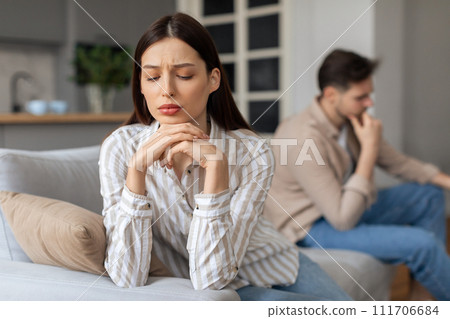 Concerned young woman with upset man in background Concerned young woman with upset man in background 111706684