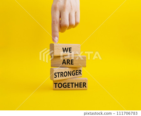 We are stronger together symbol. Wooden blocks with words We are stronger together. Businessman hand. Beautiful yellow background. We are stronger together concept. Copy space. We are stronger together symbol. Wooden blocks with words We are stronger together. Businessman hand. Beautiful yellow background. We are stronger together concept. Copy space. 111706783