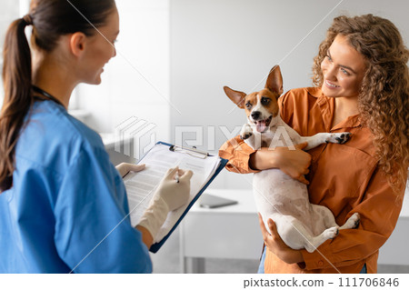 Happy Jack Russell with owner reviewing chart with vet Happy Jack Russell with owner reviewing chart with vet 111706846