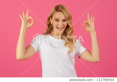 blonde woman showing OKAY gesture with both hands against pink blonde woman showing OKAY gesture with both hands against pink 111706910