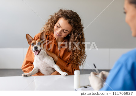 Joyful dog with female owner at vet's office, engagement and care 111706927