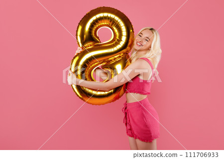 Happy woman with 8 balloon in pink outfit 111706933