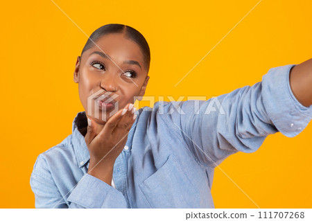 Flirty African American Lady Blowing A Kiss Making Selfie, Studio 111707268