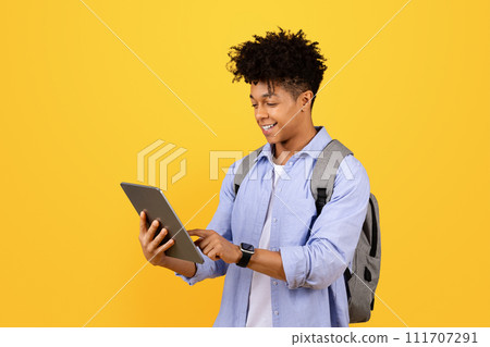 Happy black male student with tablet and backpack 111707291