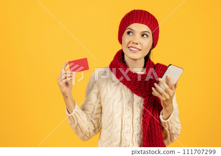 Lady with phone and credit card shops online, yellow backdrop Lady with phone and credit card shops online, yellow backdrop 111707299