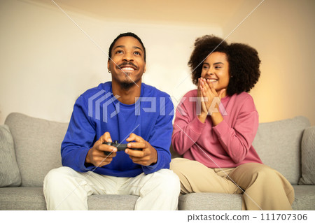 Happy black spouses play videogames on weekend at home Happy black spouses play videogames on weekend at home 111707306