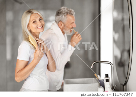 Morning Rituals. Happy Mature Couple Making Self-Care Routine Near Mirror In Bathroom 111707347