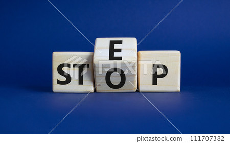 Step vs Stop symbol. Wooden cubes with words Stop and Step. Beautiful deep blue background. Step vs Stop and business concept. Copy space Step vs Stop symbol. Wooden cubes with words Stop and Step. Beautiful deep blue background. Step vs Stop and business concept. Copy space 111707382