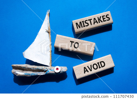 Mistakes to Avoid symbol. Wooden blocks with words Mistakes to Avoid. Beautiful blue background with boat. Business and Mistakes to Avoid concept. Copy space. 111707430