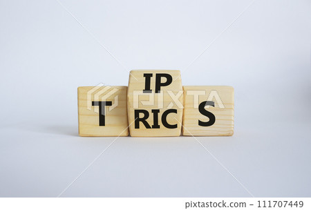 Tips and Tricks symbol. Wooden cubes with words Tricks and Tips. Beautiful white background. Business and Tips and Tricks concept. Copy space 111707449