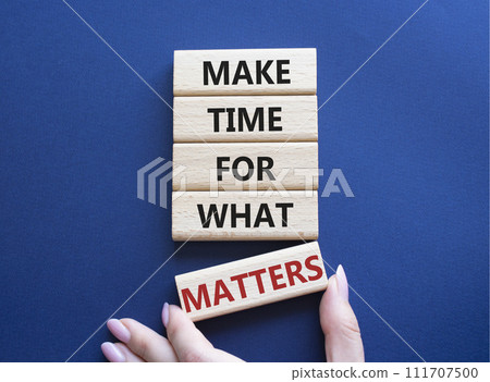 Important thing symbol. Wooden blocks with words Make time for what matters. Businessman hand. Beautiful deep blue background. Business and important thing concept. Copy space. 111707500