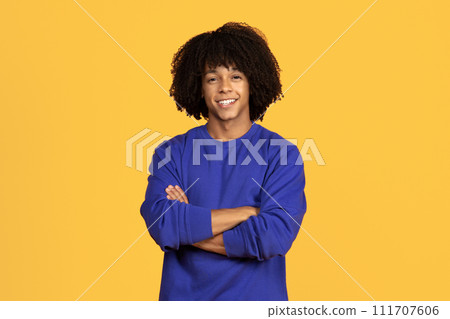 Handsome Black Millennial Guy Posing With Crossed Arms And Looking At Camera Handsome Black Millennial Guy Posing With Crossed Arms And Looking At Camera 111707606