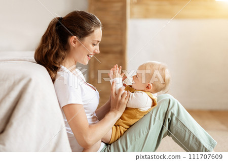 Side view happy mother and little kid playing at home 111707609