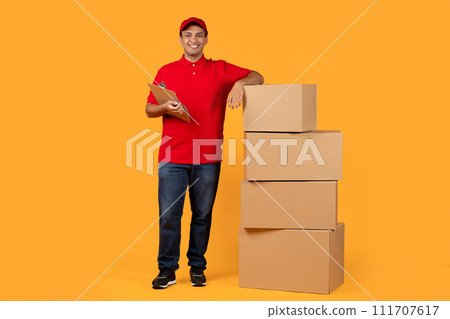delivery man leaning on cardboard parcels boxes stack in studio delivery man leaning on cardboard parcels boxes stack in studio 111707617