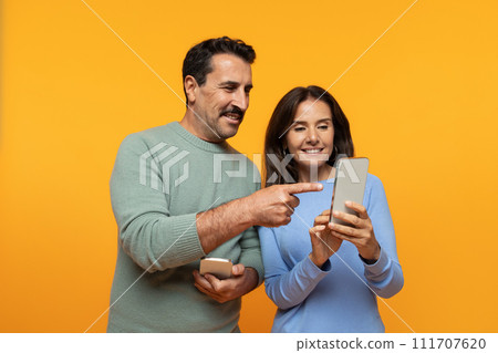 Positive old european family watch video on phone, point finger at smartphone 111707620