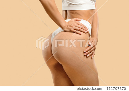Unrecognizable young fit woman in white underwear showing smooth skin on buttocks Unrecognizable young fit woman in white underwear showing smooth skin on buttocks 111707870
