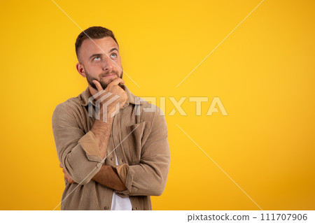 Focused pensive young caucasian man with beard in casual thinks 111707906