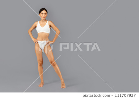 Smiling confident european slim millennial lady in white underwear enjoy perfect body care 111707927
