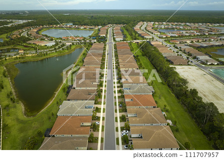 View from above of densely built residential houses in closed living clubs in south Florida. American dream homes as example of real estate development in US suburbs View from above of densely built residential houses in closed living clubs in south Florida. American dream homes as example of real estate development in US suburbs 111707957