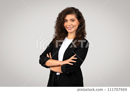 Confident businesswoman with crossed arms smiling Confident businesswoman with crossed arms smiling 111707989