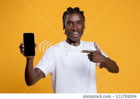 Happy Young Black Man Pointing At Smartphone With Blank Screen In Hand Happy Young Black Man Pointing At Smartphone With Blank Screen In Hand 111708004