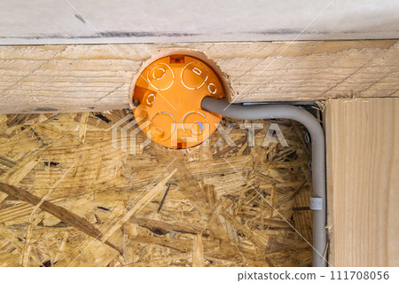 New electrical installation, socket plastic boxes and electrical cables on the wall, renovation concept. Electrical wiring installation. 111708056