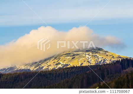 Mountain with white puffy cloud on it Mountain with white puffy cloud on it 111708067