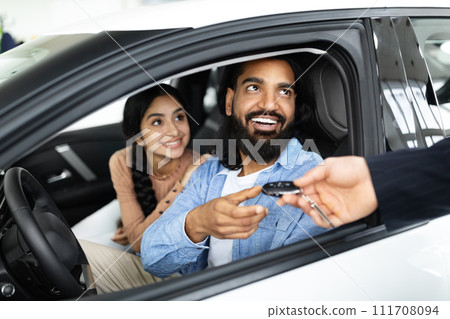 Cheery young family buying new vehicle at modern showroom 111708094